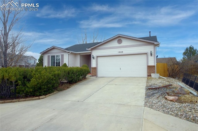 ranch-style home featuring a garage, brick siding, driveway, and fence