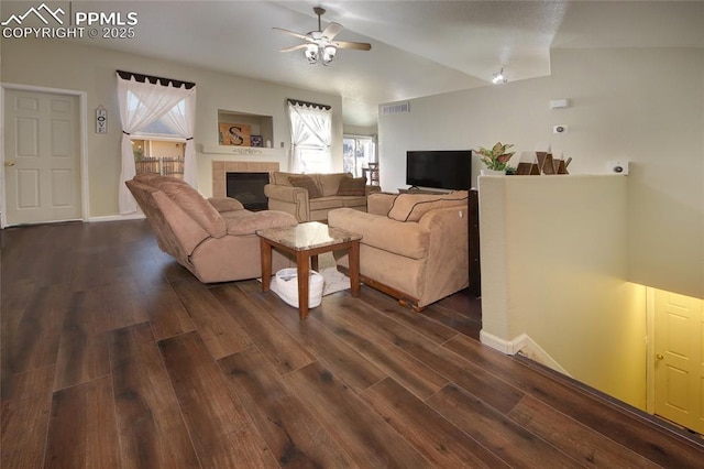 living room with ceiling fan, a fireplace, and dark hardwood / wood-style flooring