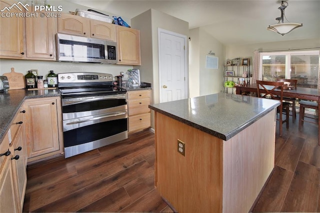 kitchen with light brown cabinets, dark wood-style flooring, appliances with stainless steel finishes, a center island, and dark countertops