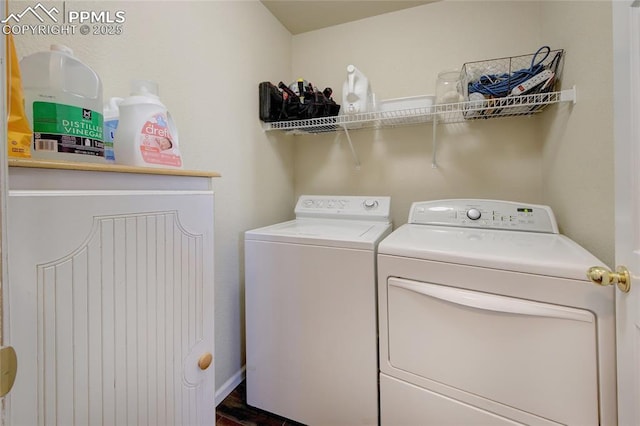 laundry area with laundry area, washing machine and clothes dryer, and baseboards