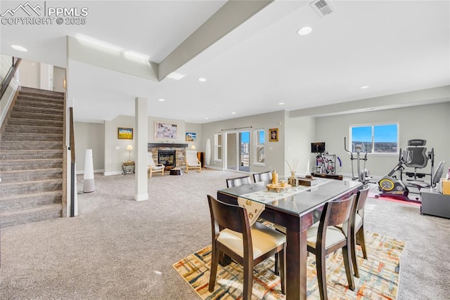 carpeted dining space with a fireplace