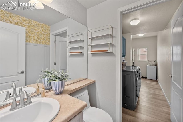 bathroom featuring separate washer and dryer, vanity, wood-type flooring, and toilet