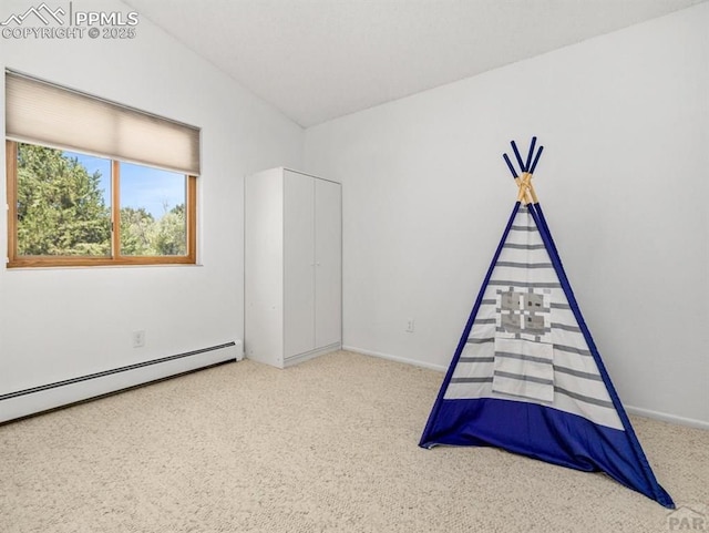 unfurnished bedroom with lofted ceiling, carpet, a baseboard radiator, and baseboards