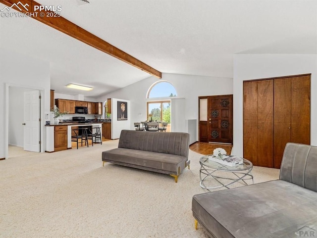 living area with lofted ceiling with beams and light colored carpet