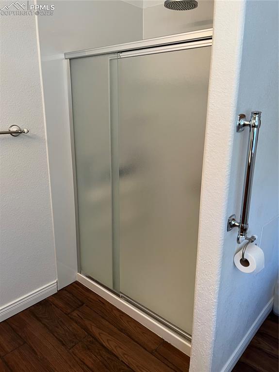 bathroom with hardwood / wood-style flooring and a shower with door