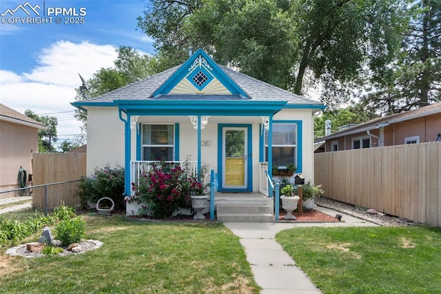 view of front of property with a shingled roof, fence private yard, stucco siding, and a front yard