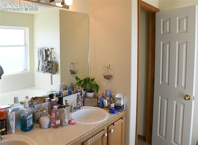 bathroom featuring vanity and a washtub