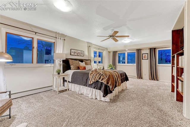 carpeted bedroom with a textured ceiling and a baseboard heating unit