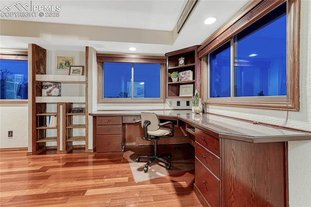 home office featuring built in desk and light wood-type flooring