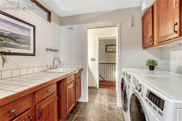 laundry room featuring cabinets, sink, and washer and dryer