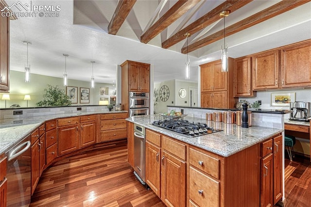 kitchen with light stone counters, appliances with stainless steel finishes, a center island, and hanging light fixtures