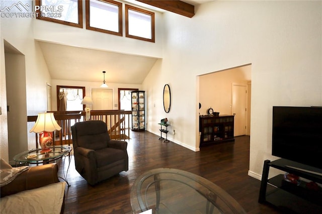 living room featuring a towering ceiling, dark wood-style floors, baseboards, and beamed ceiling