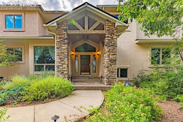 entrance to property featuring stucco siding and stone siding