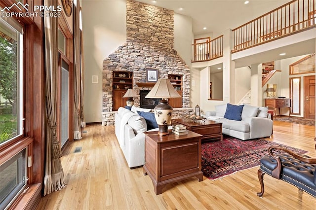 living area with stairs, a high ceiling, and wood finished floors