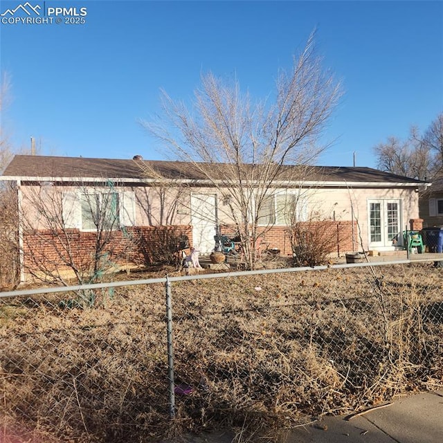 view of side of home with brick siding and fence
