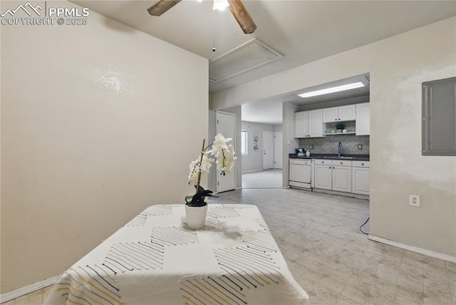 dining room featuring electric panel, baseboards, attic access, and a ceiling fan