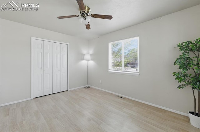 unfurnished bedroom with wood finished floors, baseboards, and visible vents