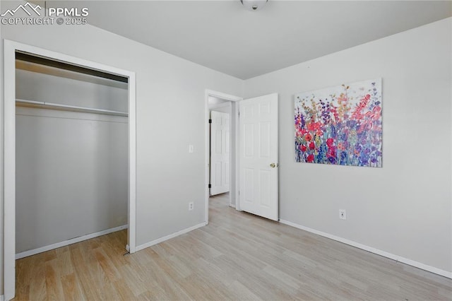 unfurnished bedroom featuring a closet, baseboards, and wood finished floors
