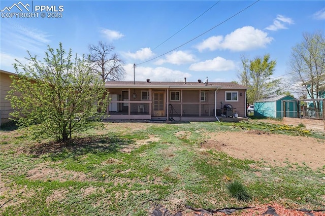 back of property featuring fence, a yard, and a sunroom