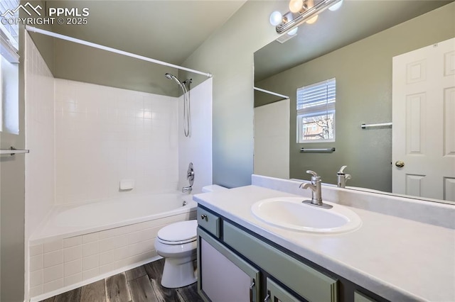 full bathroom featuring vanity, tiled shower / bath, hardwood / wood-style floors, and toilet