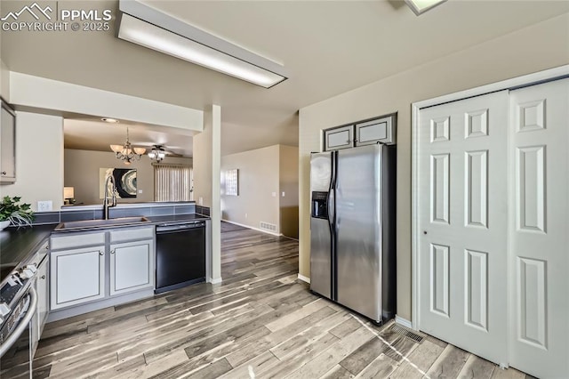 kitchen featuring white cabinetry, stainless steel appliances, sink, and hanging light fixtures