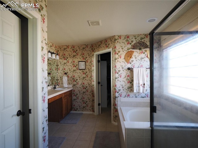 bathroom with vanity, tiled bath, and tile patterned floors