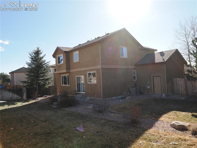 rear view of house featuring a lawn and central air condition unit