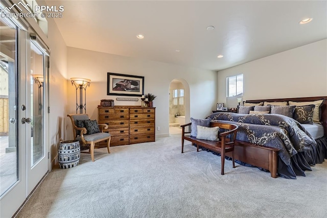 carpeted bedroom featuring french doors and connected bathroom