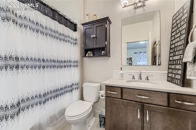 bathroom with vanity, toilet, and curtained shower