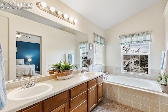 bathroom featuring vaulted ceiling, a relaxing tiled tub, and vanity