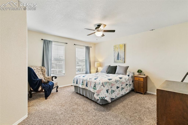 carpeted bedroom featuring ceiling fan and a textured ceiling