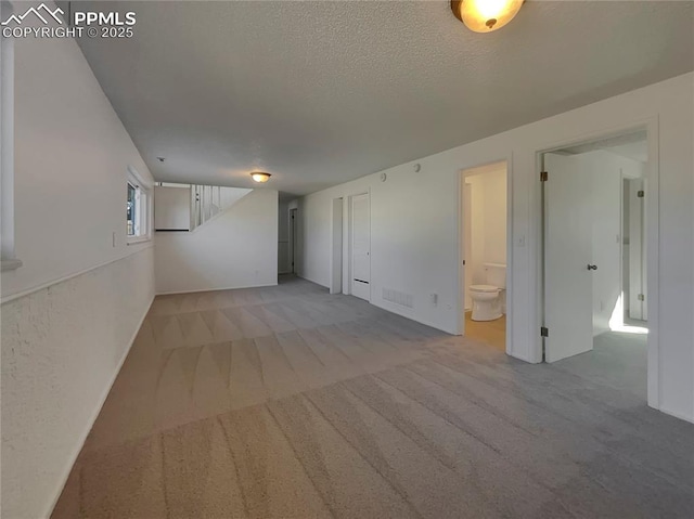 interior space with light colored carpet and a textured ceiling