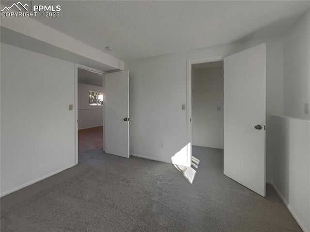 carpeted spare room with a textured ceiling