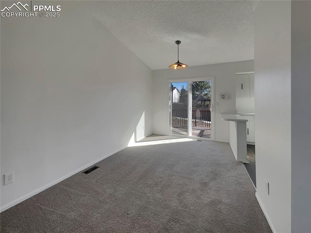 unfurnished living room featuring carpet, lofted ceiling, and a textured ceiling