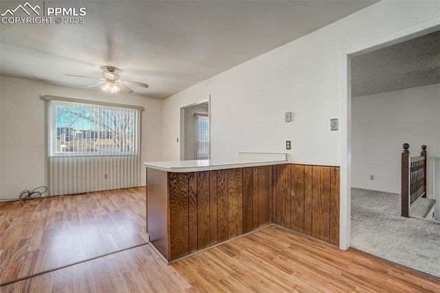 kitchen featuring kitchen peninsula, ceiling fan, and light hardwood / wood-style flooring