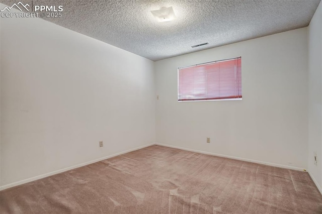 carpeted spare room featuring a textured ceiling