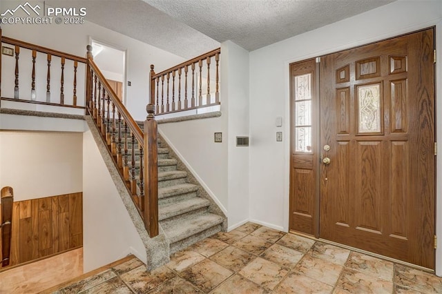 foyer entrance with a textured ceiling