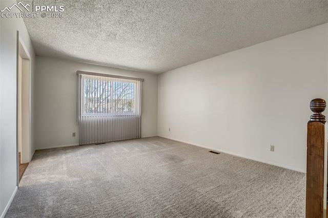 carpeted spare room featuring a textured ceiling