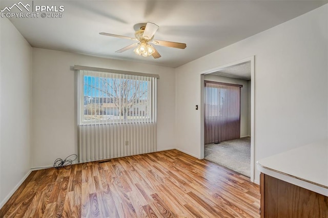 empty room with ceiling fan and light hardwood / wood-style floors