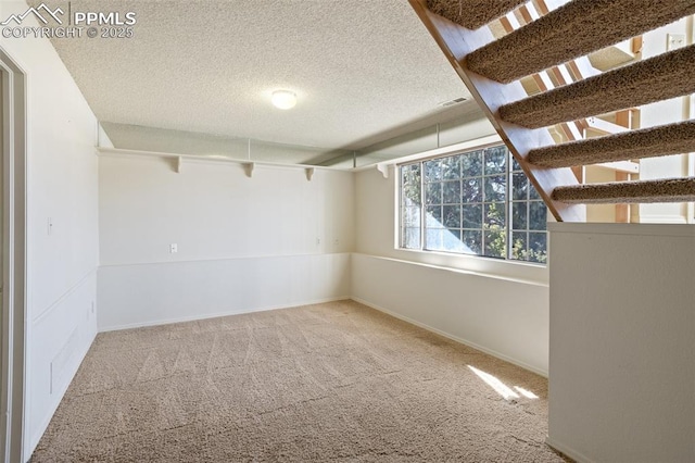 unfurnished room featuring a textured ceiling and carpet