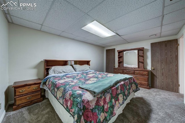 carpeted bedroom with a drop ceiling