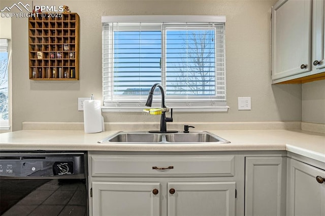 kitchen featuring white cabinetry, dishwasher, and sink