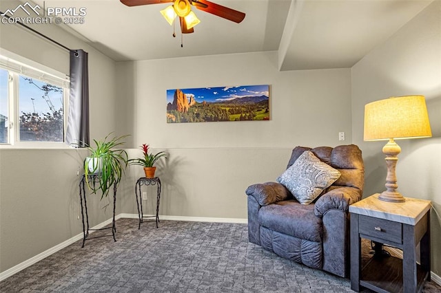 living area with ceiling fan and dark carpet