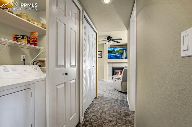 clothes washing area with a tile fireplace, dark carpet, ceiling fan, and independent washer and dryer