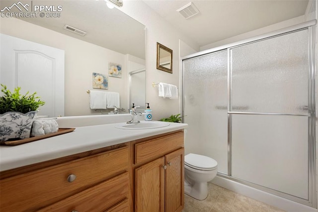 bathroom featuring walk in shower, tile patterned floors, vanity, and toilet