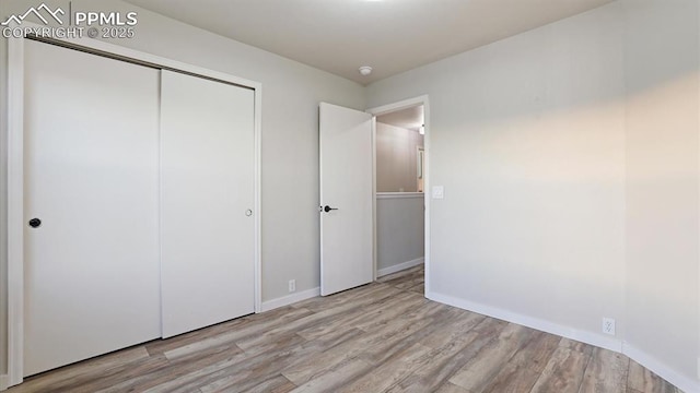 unfurnished bedroom with light hardwood / wood-style flooring and a closet