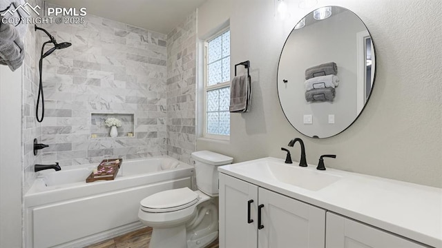 full bathroom with vanity, toilet, tiled shower / bath combo, and hardwood / wood-style floors