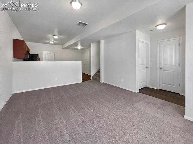 unfurnished living room featuring dark colored carpet