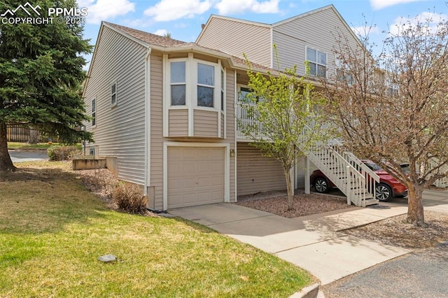 view of front of home with an attached garage, driveway, and a front yard