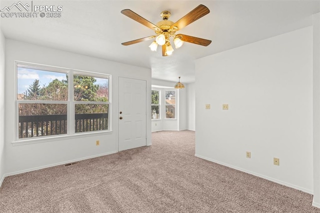 empty room featuring ceiling fan, baseboards, carpet flooring, and visible vents
